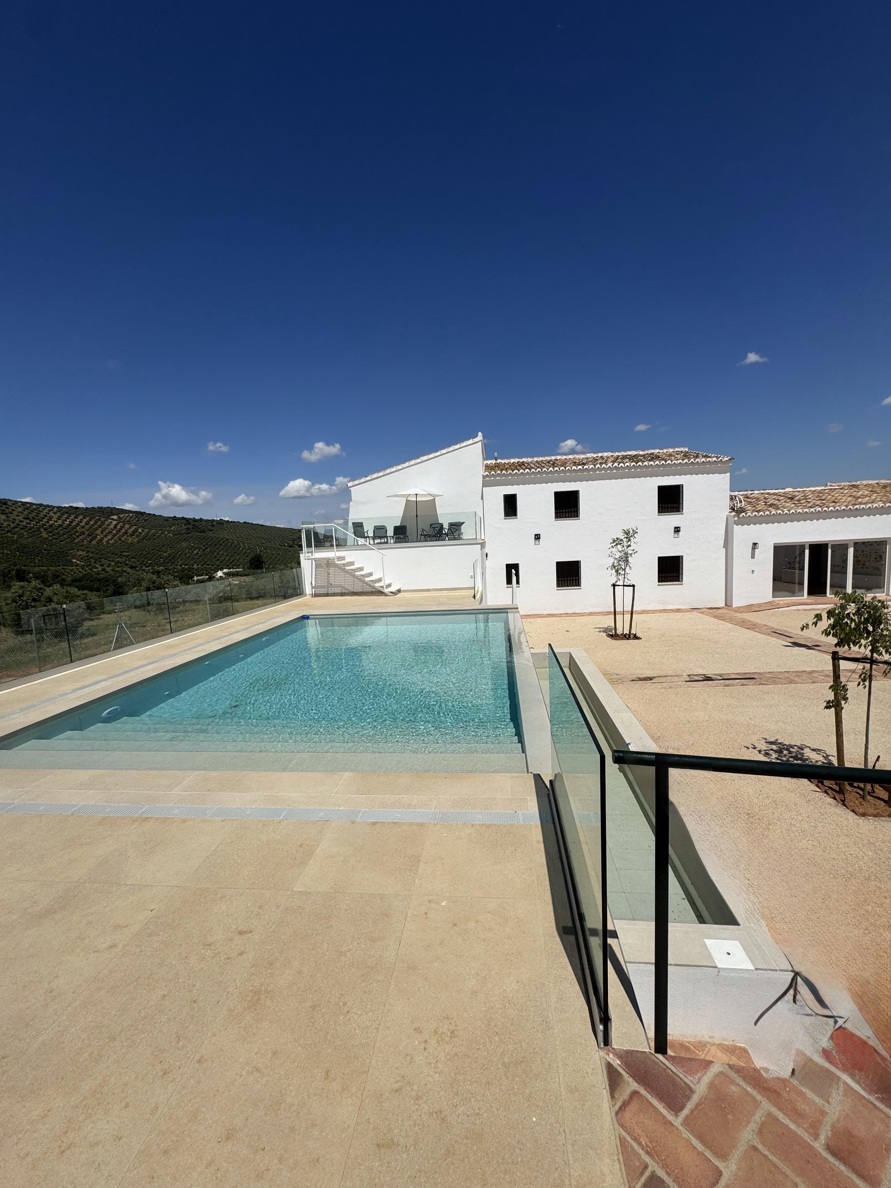 Piscina exterior infinita con vistas a los olivares